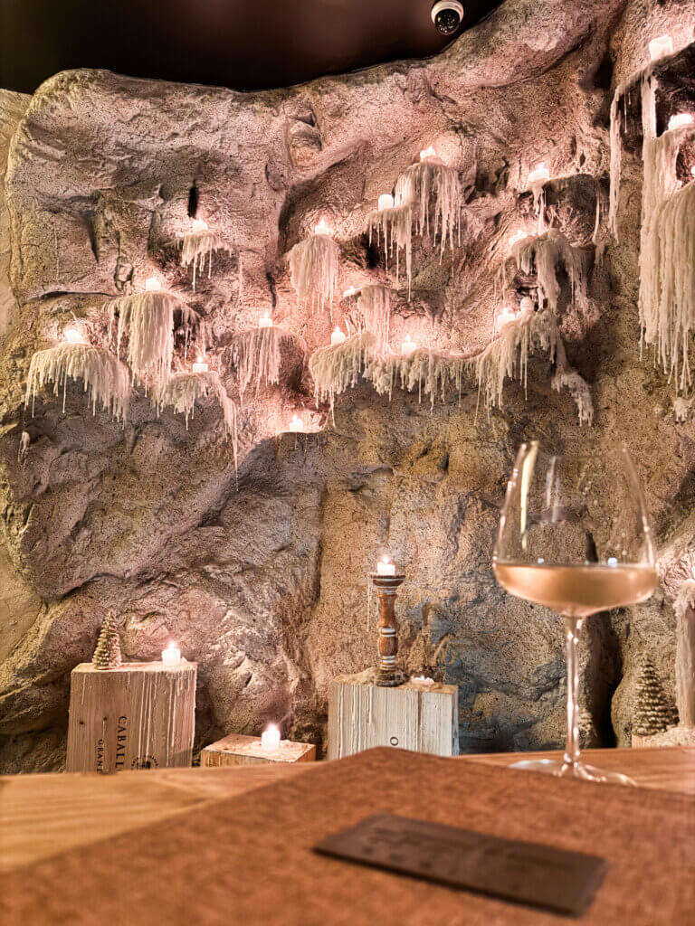 Parede de pedra natural com velas do Grotta Cucina